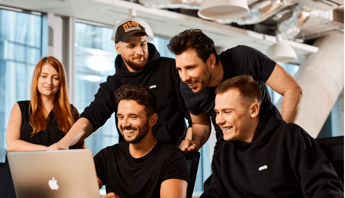 A group of five people having fun putting together a website.